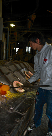 混ぜ合わせた原料をるつぼの中に入れ、400度から1,300度の熱でおよそ12時間かけて溶かし飴状にします。真っ赤に溶けたガラスは、ホウトウという長い鉄の棒で巻き取られます。